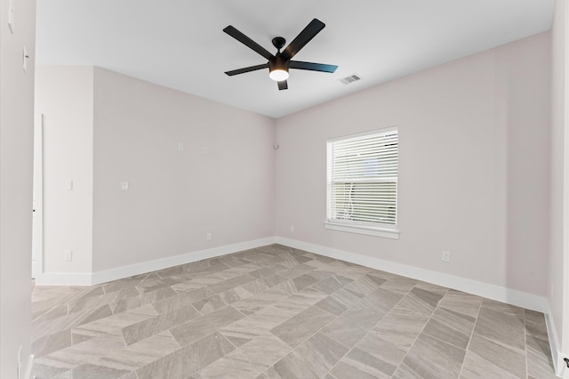 unfurnished room with a ceiling fan, visible vents, and baseboards