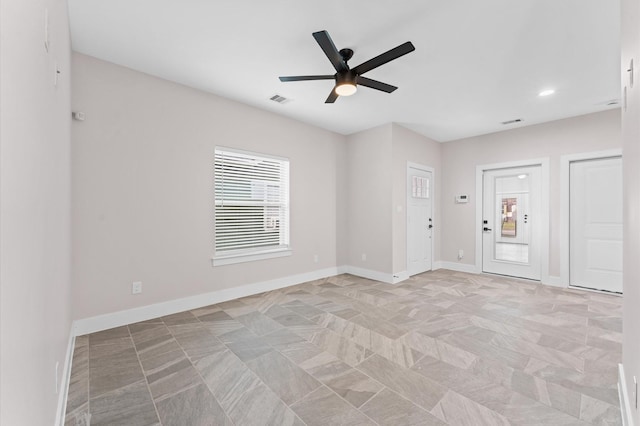 empty room featuring visible vents, ceiling fan, and baseboards