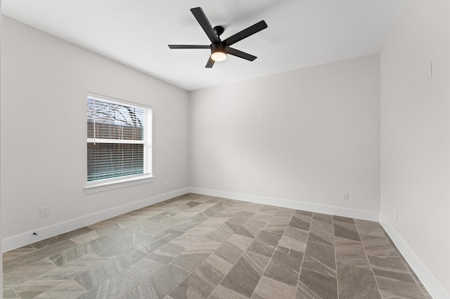 spare room with baseboards and ceiling fan