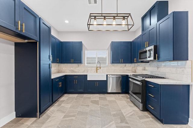 kitchen with decorative backsplash, blue cabinetry, appliances with stainless steel finishes, and a sink