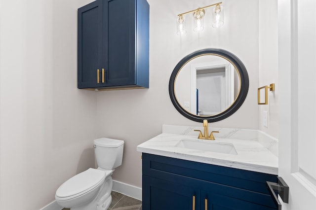 bathroom with vanity, toilet, and baseboards