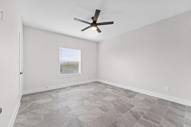 spare room with baseboards and a ceiling fan