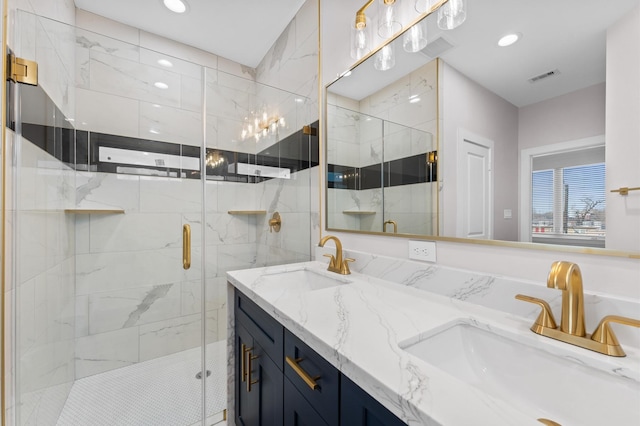 bathroom with recessed lighting, visible vents, a marble finish shower, and a sink