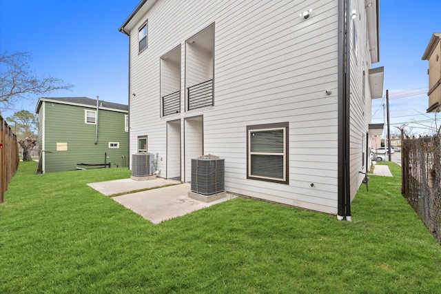 back of property with fence, cooling unit, a patio area, and a yard