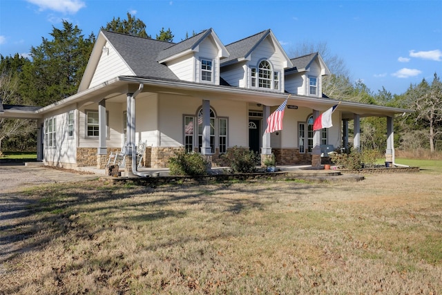 country-style home with stone siding and a front lawn