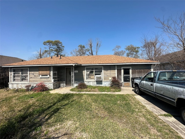 ranch-style home with a front lawn and roof with shingles