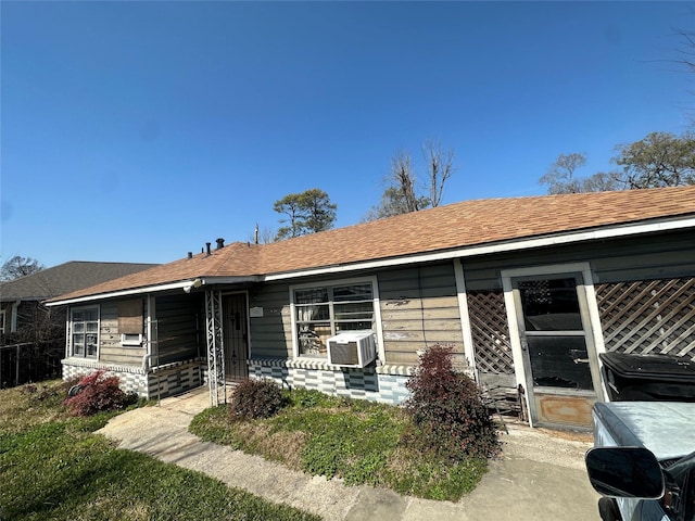 ranch-style house with roof with shingles and cooling unit