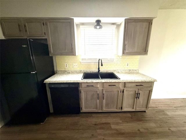 kitchen with dark wood-style flooring, a sink, backsplash, and black appliances