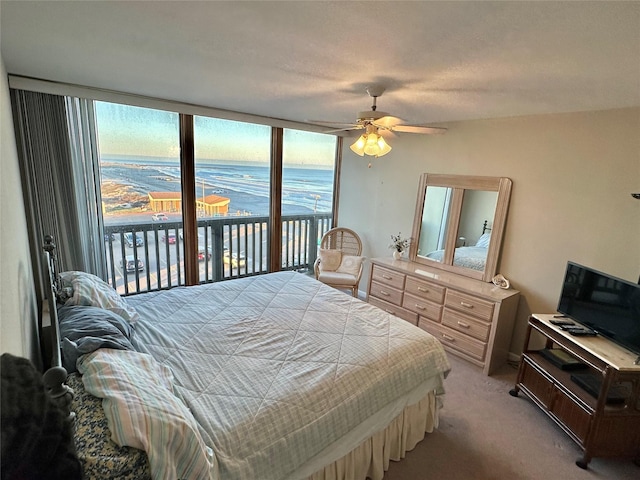 bedroom featuring access to outside, a ceiling fan, and light colored carpet