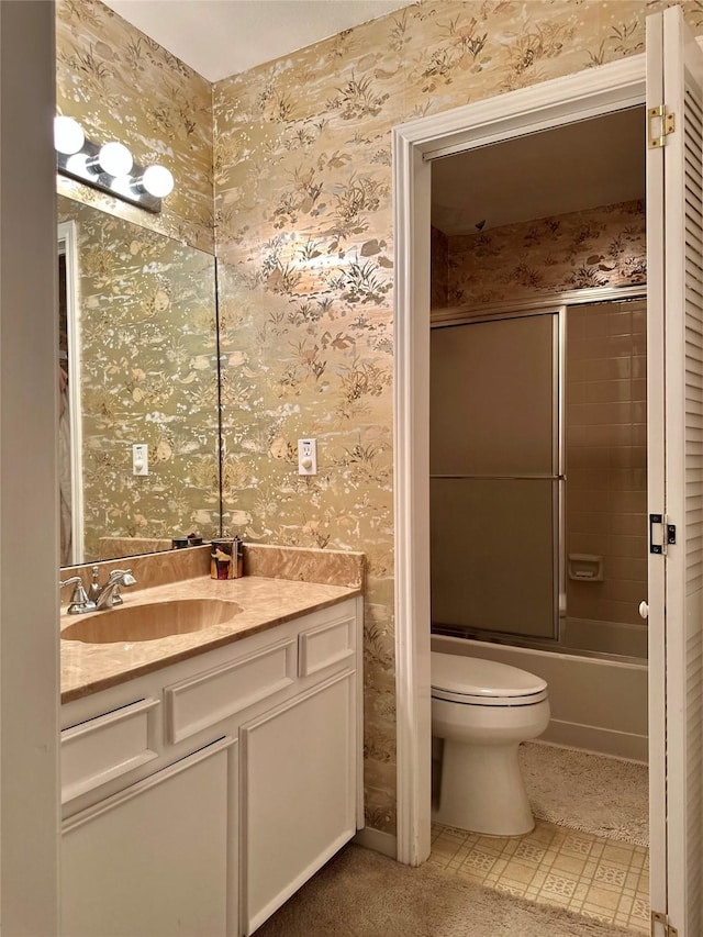 full bath with toilet, wallpapered walls, shower / bath combination with glass door, and vanity