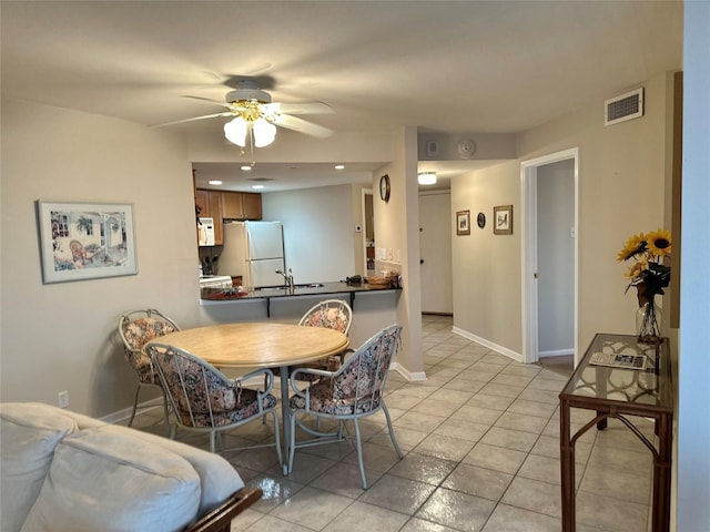 dining space with light tile patterned floors, baseboards, visible vents, and a ceiling fan