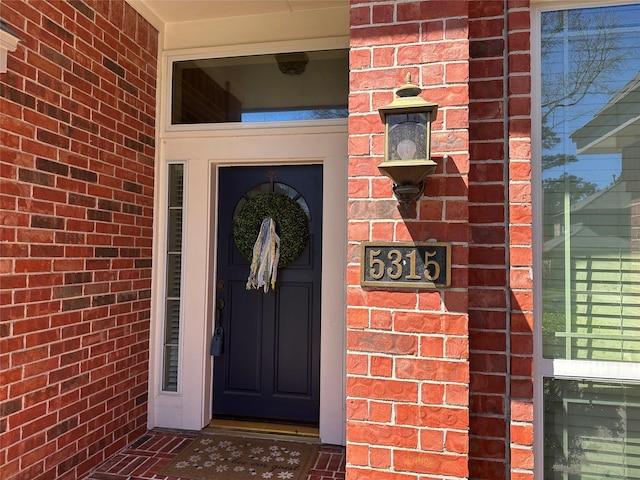 doorway to property featuring brick siding