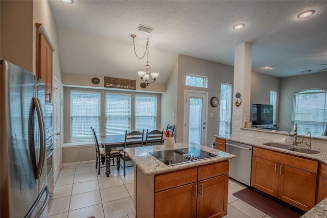 kitchen featuring brown cabinets, a sink, light stone counters, appliances with stainless steel finishes, and light tile patterned flooring