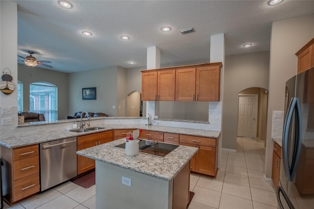 kitchen featuring a sink, arched walkways, visible vents, and stainless steel appliances