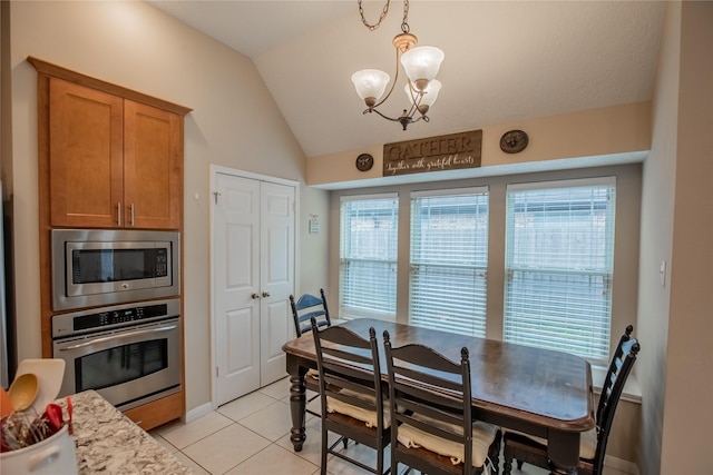 dining room featuring lofted ceiling, a notable chandelier, and light tile patterned floors