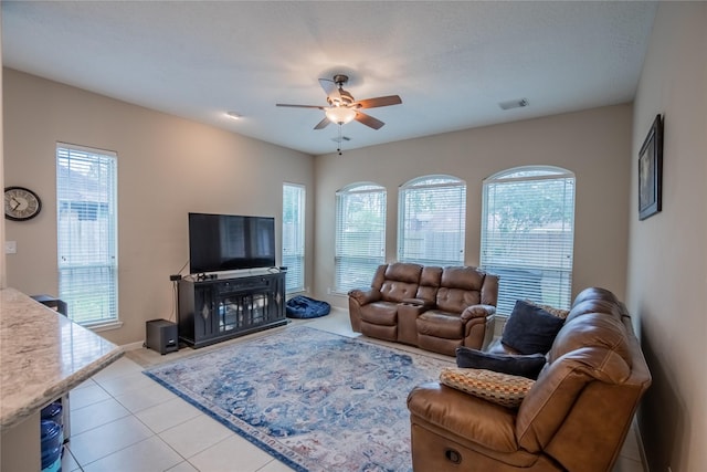 living room with tile patterned floors, a healthy amount of sunlight, visible vents, and ceiling fan