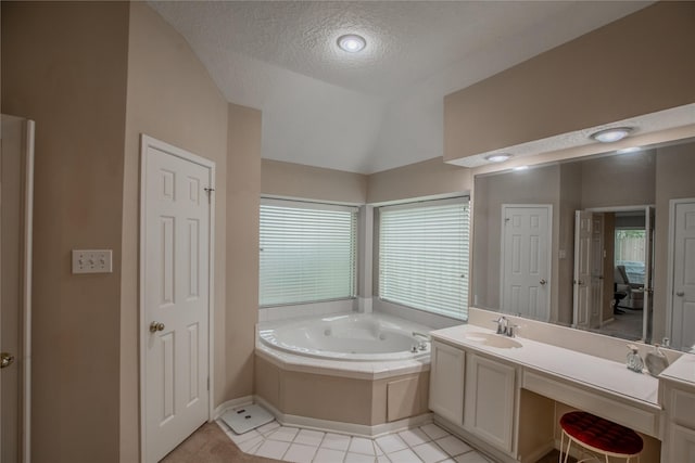 full bathroom featuring vanity, a garden tub, vaulted ceiling, tile patterned floors, and a textured ceiling