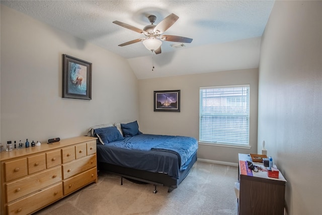 bedroom with baseboards, ceiling fan, vaulted ceiling, a textured ceiling, and light colored carpet