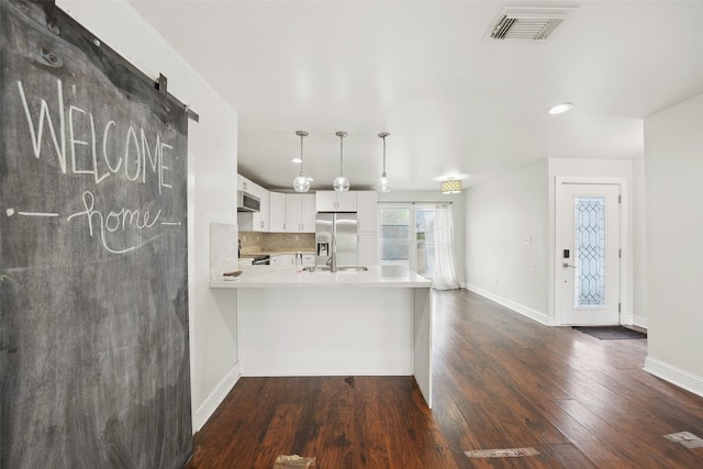 kitchen with visible vents, backsplash, dark wood finished floors, light countertops, and stainless steel appliances