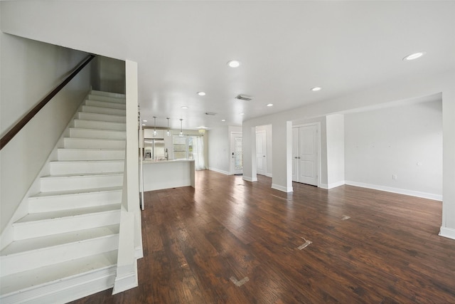 unfurnished living room with stairs, recessed lighting, baseboards, dark wood-type flooring, and visible vents