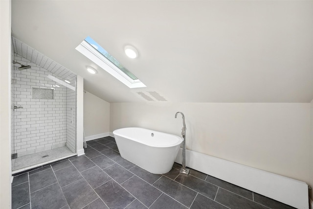 full bathroom featuring tile patterned flooring, lofted ceiling with skylight, a freestanding tub, and tiled shower