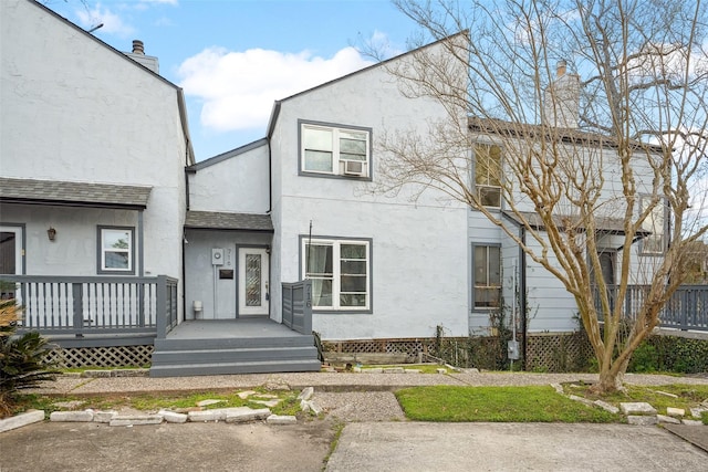 view of front of house featuring a chimney and stucco siding