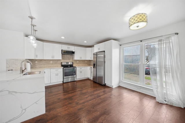 kitchen featuring a sink, light stone countertops, backsplash, and stainless steel appliances