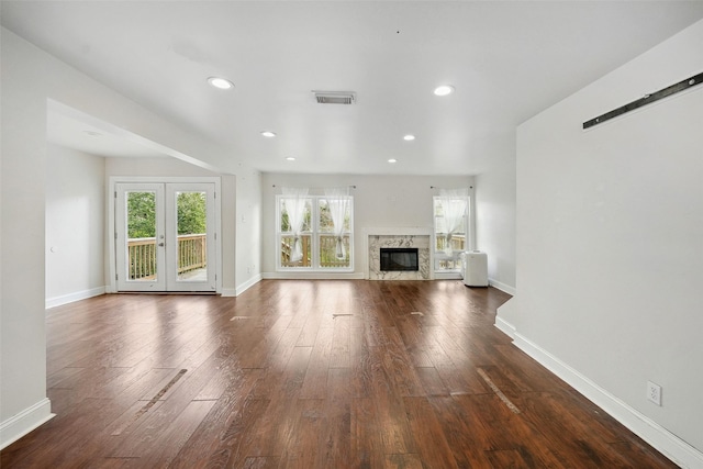 unfurnished living room featuring baseboards, dark wood-style flooring, and a high end fireplace