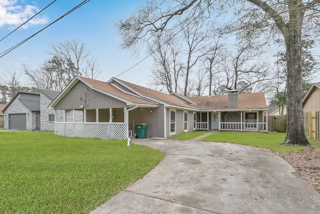 view of front of home featuring a chimney, a porch, a front yard, fence, and driveway