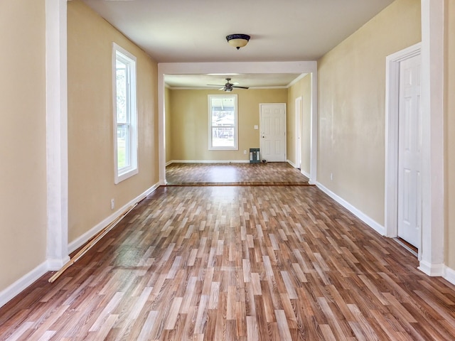 unfurnished room with a ceiling fan, baseboards, and wood finished floors