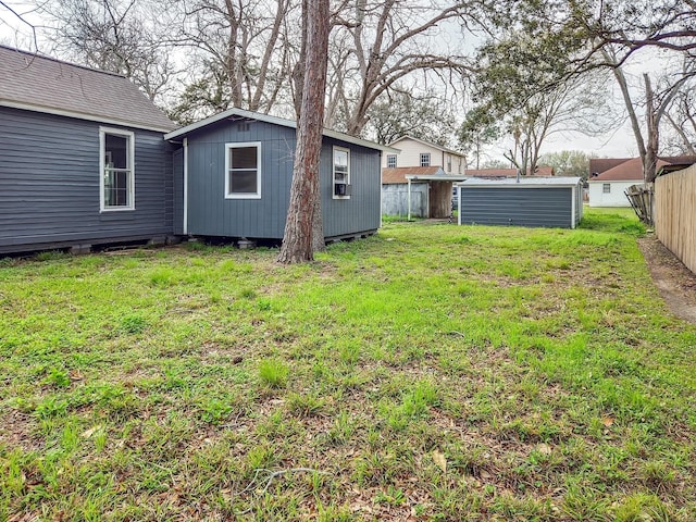 view of yard with fence and an outdoor structure