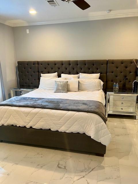 unfurnished bedroom featuring marble finish floor, visible vents, ornamental molding, and a ceiling fan