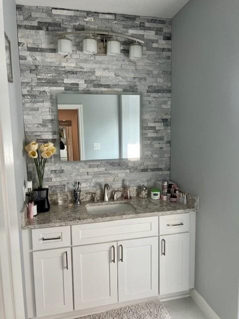 bar with backsplash, a sink, and baseboards