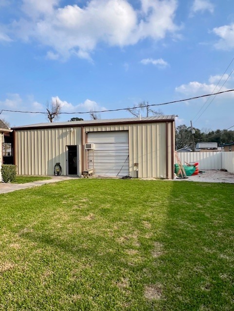 view of pole building with a lawn and fence