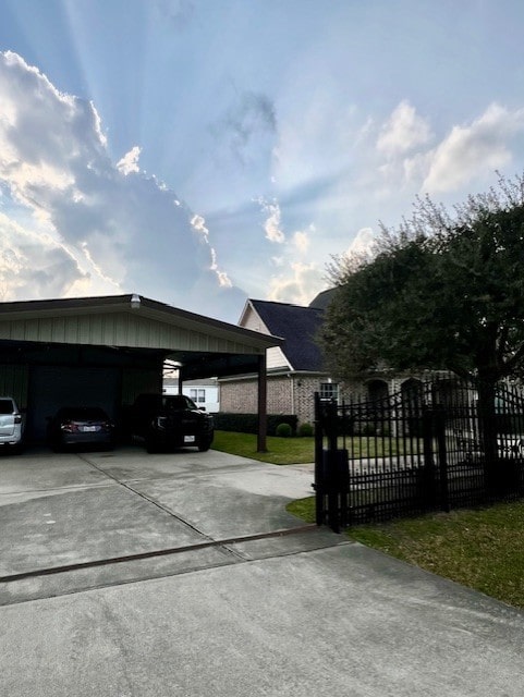 view of parking with a carport and fence