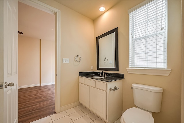 half bath with recessed lighting, toilet, vanity, tile patterned flooring, and baseboards