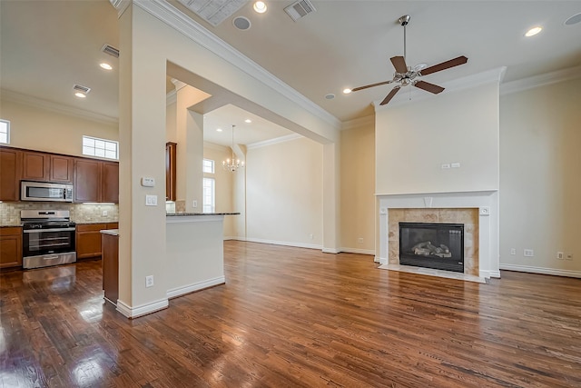 5938 Kansas St, Houston, TX 77007 - unfurnished living room with dark wood finished floors, a chandelier, a ceiling fan, a fireplace, and ornamental molding