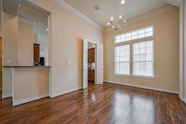 5938 Kansas St, Houston, TX 77007 - unfurnished dining area featuring a chandelier, crown molding, dark wood-type flooring, and baseboards
