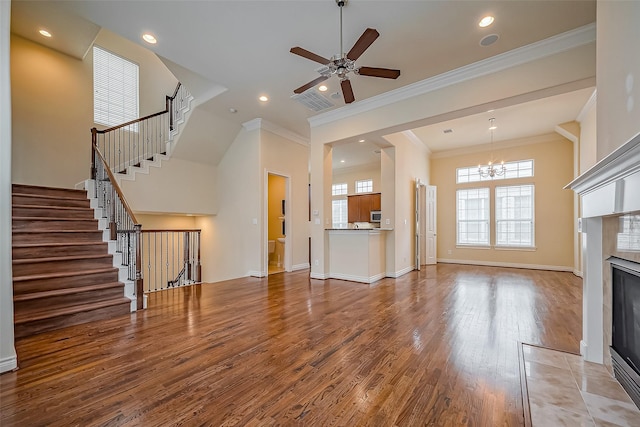 unfurnished living room with baseboards, a tiled fireplace, wood finished floors, and crown molding