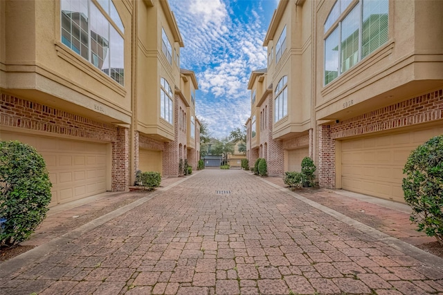 view of home's community featuring decorative driveway and an attached garage