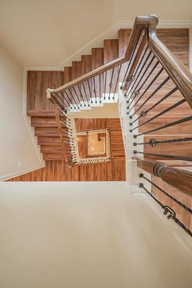 staircase with baseboards and wood finished floors