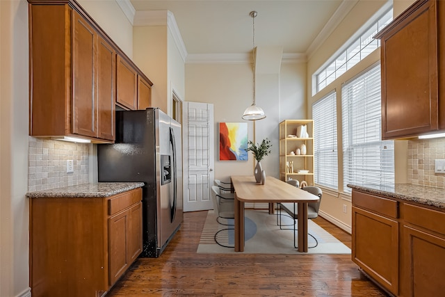 kitchen with crown molding, brown cabinets, dark wood finished floors, and stainless steel refrigerator with ice dispenser