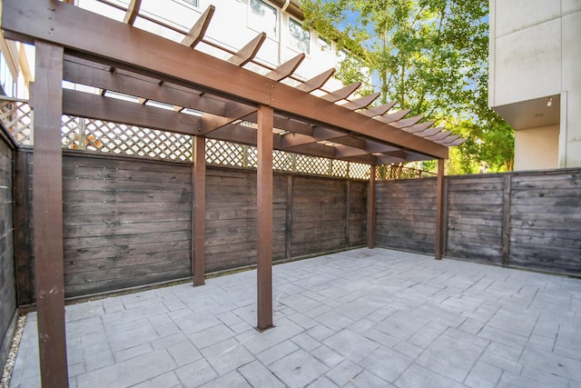 view of patio with a pergola and fence