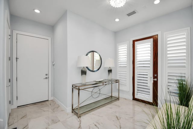 foyer entrance with visible vents, recessed lighting, marble finish floor, and baseboards