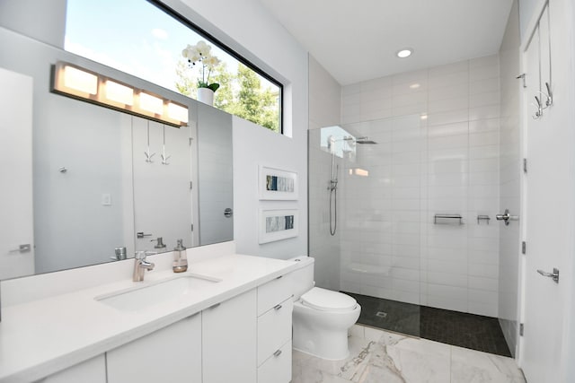 bathroom with tiled shower, marble finish floor, toilet, and vanity