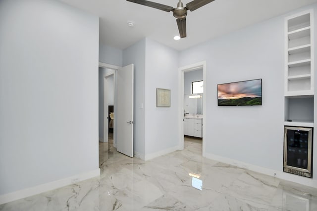 unfurnished bedroom featuring wine cooler, baseboards, marble finish floor, and ceiling fan