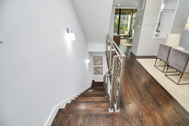 stairs featuring expansive windows, baseboards, and wood finished floors