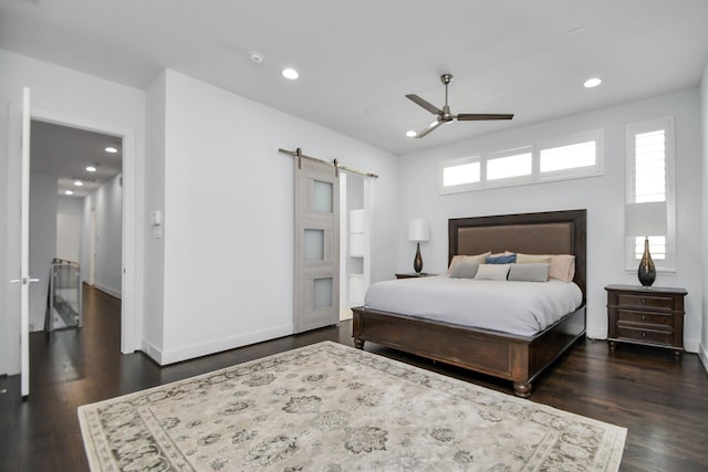 bedroom with recessed lighting, baseboards, a barn door, and dark wood-style flooring