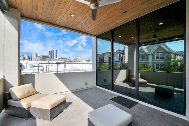 view of patio / terrace with a balcony, a view of city, and a ceiling fan