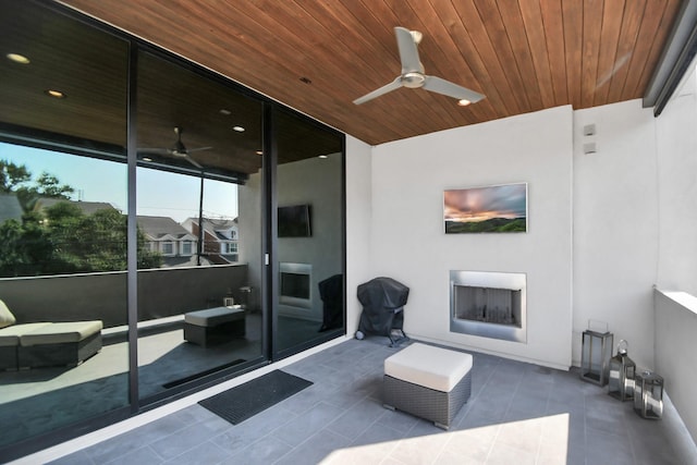 view of patio featuring a ceiling fan and an outdoor fireplace